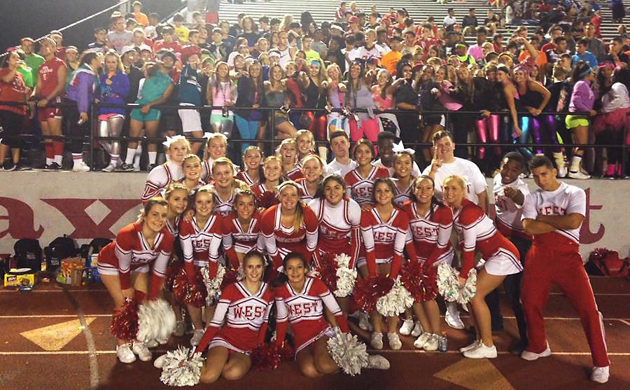 Cheerleaders pose with the fans who dressed in a 1980s theme for the North football game.