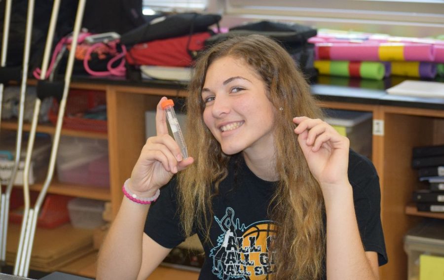Lauren Oostendorp is posing for a photo with her very own DNA sample.