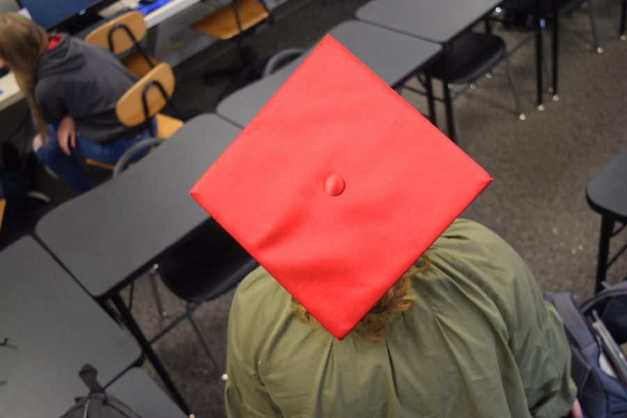 A Davenport West High student demonstrates a bare graduation cap.