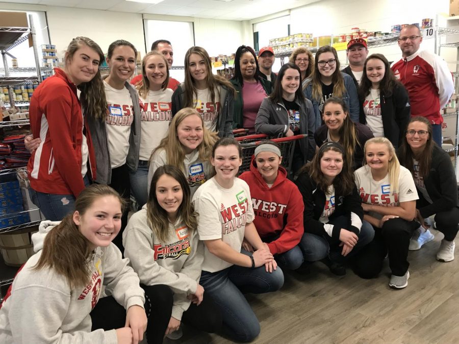Some of the softball team and their coaches volunteering at the JB Young Food Bank.