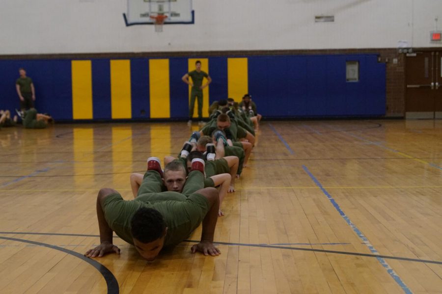 Army JROTC students are in push-up formation for physical training.