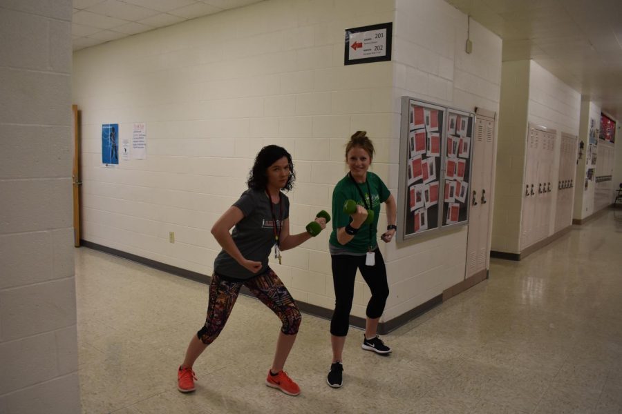 English teachers Katie Choate and Alissa Hansen bulk up for the summer during five-minute passing time in honor of Workout Wednesday.