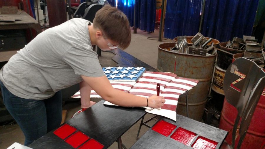 Junior Madison White hand paints the American flag.