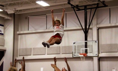 Senior and flyer Miranda Schwein in the midst of her stunt, preparing to be caught by juniors Hailey Hansen and Ivori Bly and senior Addison Flynn. This stunt was performed at one of the many late night practices required to perfect their routine for state.