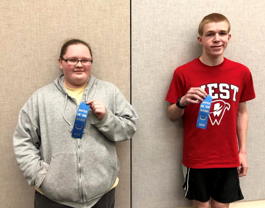 Senior Skylar Hintze (Left) and Junior Anton Kordick (Right) holding participation ribbons after the Battle of the Books competition (2017-18) at the Bettendorf Public Library.  
