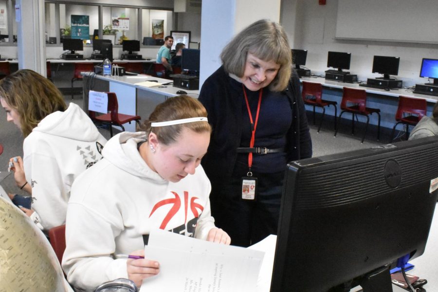 Language arts teacher Pat Sheehey assists senior Brooke Hildebrant with paper revisions sporting a smile. “I think it is very important to develop skills in English, and to write well, speak well, and to read,” Sheehey said about the subject she has been teaching for the past 50 years.