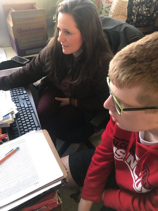 Spanish teacher Stephanie Hansen helps her advisory student sophomore Caleb Heskett sign up for Falcon Flex. Hansen allows her advisory students to sit in the back chairs by her desk, allowing conversations to flow throughout the class.
