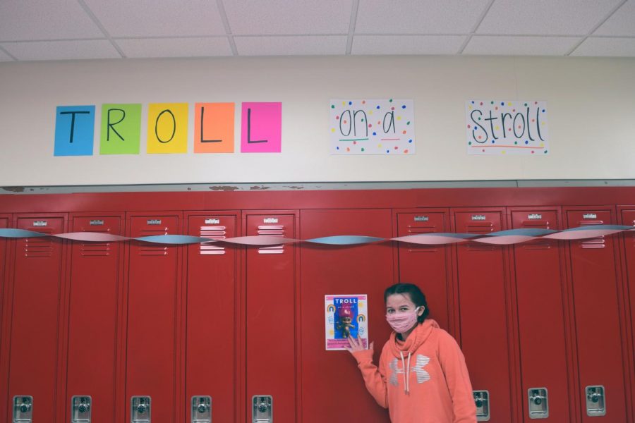 Student senator Savannah Haskins 23 points to one of the custom signs placed around the halls of West.  Student Senate plans to promote Troll on a Stroll as long as students and staff are having a good time with it.