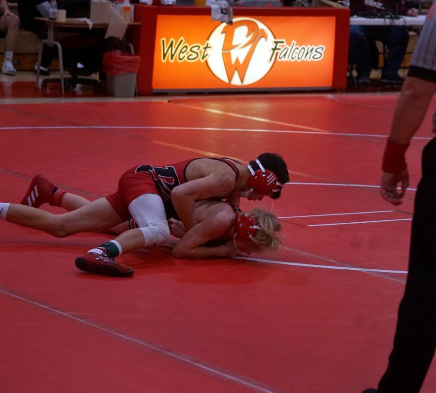 Ayden Nicklaus ‘22  takes an opponent to the mat during a home meet at West. Nicklaus’ was influenced by his father, and has been wrestling since second grade, because he enjoys it. “Wrestling is a very challenging sport, but if you overcome the challenges, it’s going to make you a better overall person,” Nicklaus said.
