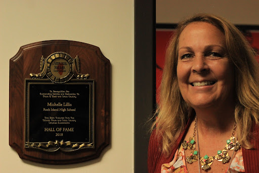 New athletic director Michelle Lillis stands proudly by her hall of fame plaque. She was recognized as the first female athletic director at her previous school, Rock Island High School. 
