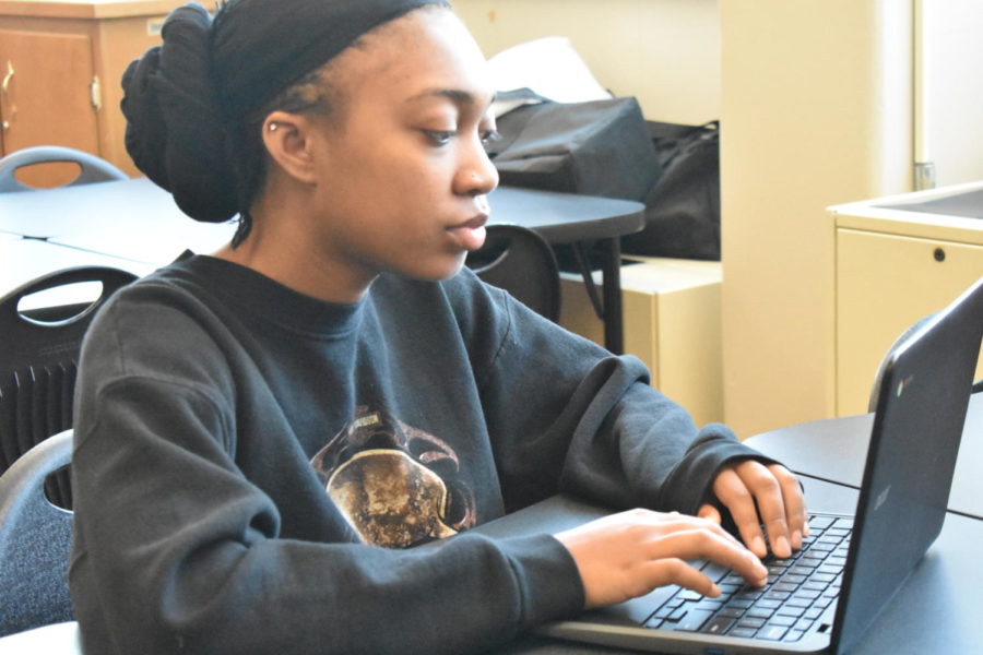 Angele Hill ‘23 sits with her Chromebook. Hill applied to many colleges this year, none of which were in Iowa. “Obviously a lot of people here go to like UNI or Iowa…so, it was [scary],” Hill said.