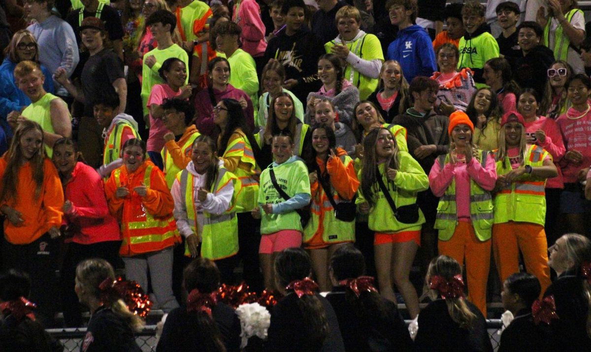 The student section, dressed in neon, join the cheerleaders to do The Falcon Train cheer.
