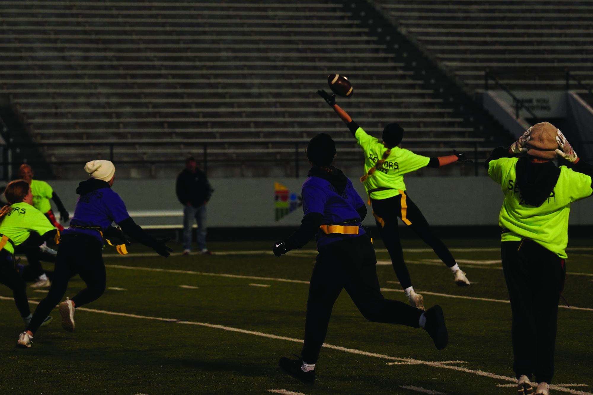 Emmaly Maylum ‘25 reaches for the night sky as she attempts to catch the football.